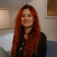 Dana Bar-Zvi sitting and smiling.